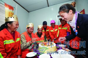 社區(qū)工作人員為集體過生日的三名環(huán)衛(wèi)工人點(diǎn)上生日蠟燭。 本報通訊員 趙松 攝